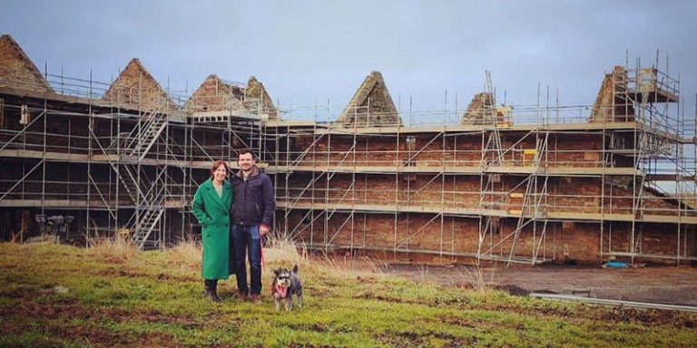 Couple in front of dilapidated building