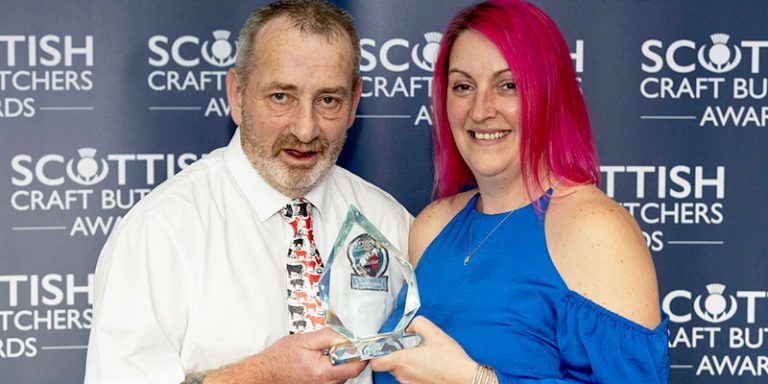 Man and woman holding trophy